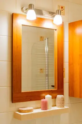 a bathroom with a mirror and a shelf with candles at Kraków Huculska Apt - Balcony, Workspace - by Rentujemy in Kraków