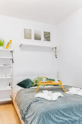 a bedroom with a bed with a table on it at Kraków Huculska Apt - Balcony, Workspace - by Rentujemy in Kraków