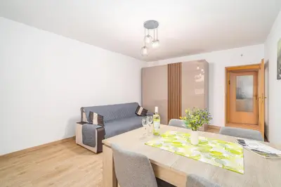 a living room with a table and a couch at Kraków Huculska Apt - Balcony, Workspace - by Rentujemy in Kraków