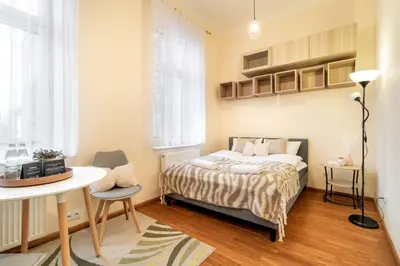 a bedroom with a bed and a table and a chair at Malila Premium Apartments Cracow Traugutta in Kraków