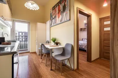 a kitchen and dining room with a table and chairs at Malila Premium Apartments Cracow Traugutta in Kraków