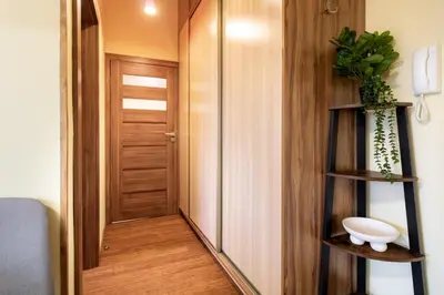 a hallway with a door and a shelf with a toilet at Malila Premium Apartments Cracow Traugutta in Kraków