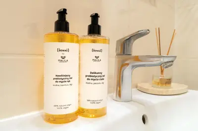 two bottles of soap sitting on top of a sink at Malila Premium Apartments Cracow Traugutta in Kraków