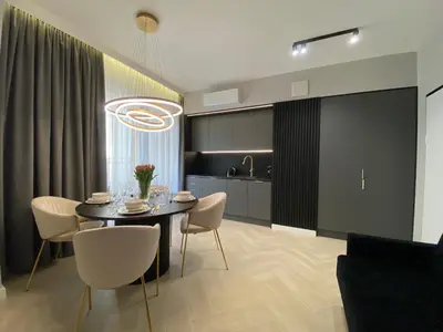 a kitchen and dining room with a table and chairs at Apartament przy Rakowickiej II Old Town in Kraków