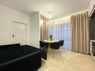 a living room with a couch and a table with chairs at Apartament przy Rakowickiej III Old Town in Kraków