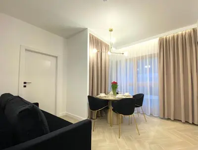 a living room with a table and chairs and a couch at Apartament przy Rakowickiej III Old Town in Kraków