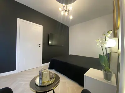 a black and white bedroom with a bed and a table at Apartament przy Rakowickiej III Old Town in Kraków