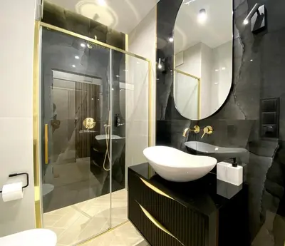 a bathroom with a sink and a glass shower at Apartament przy Rakowickiej III Old Town in Kraków