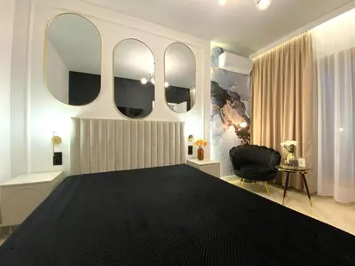 a bedroom with a large bed with three mirrors at Apartament przy Rakowickiej III Old Town in Kraków