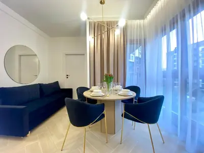 a living room with a table and blue chairs at Apartament przy Rakowickiej III Old Town in Kraków
