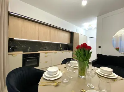 a dining room table with a vase of red roses on it at Apartament przy Rakowickiej III Old Town in Kraków