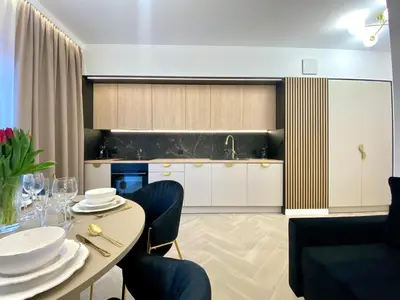a kitchen with a table with chairs and a sink at Apartament przy Rakowickiej III Old Town in Kraków