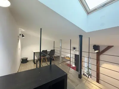 a living room with a black table and a window at Wawrzynca paradise - loft in the Kazimierz district in Kraków