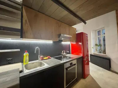 a kitchen with a sink and a red refrigerator at Wawrzynca paradise - loft in the Kazimierz district in Kraków
