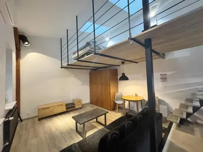 a living room with a table and a dining room at Wawrzynca paradise - loft in the Kazimierz district in Kraków