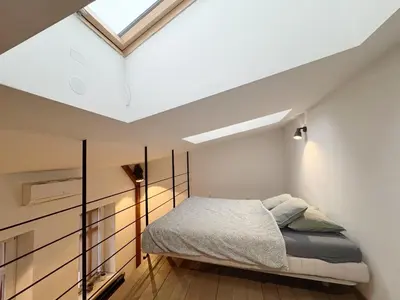 a bedroom with a bed and a skylight at Wawrzynca paradise - loft in the Kazimierz district in Kraków