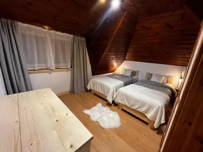 a bedroom with two beds and a wooden ceiling at Apartament 
