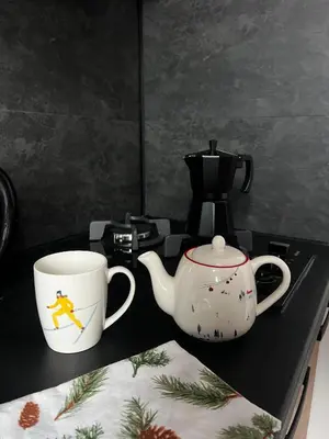 two coffee cups and a tea pot on a counter at Apartament 