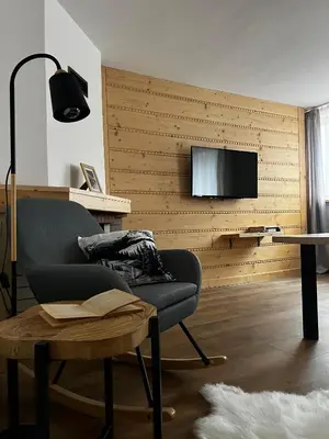 a living room with a couch and a tv on a wall at Apartament 