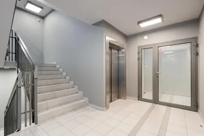an empty hallway with stairs and a glass door at Siewna Homely Apartment in Kraków