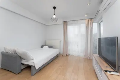 a bedroom with a bed and a flat screen tv at Siewna Homely Apartment in Kraków
