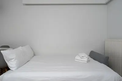 a white bed with two towels on top of it at Siewna Homely Apartment in Kraków