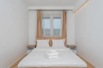 a bedroom with a white bed with towels on it at Siewna Homely Apartment in Kraków