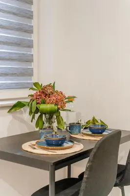 a table with three blue bowls and a plant on it at Podgórze 2-Bedrooms Apartment - 54m2, Air Con - by Rentujemy in Kraków
