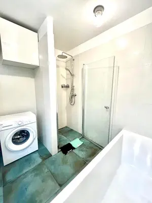 a bathroom with a washing machine and a shower at DM Sunny Apartment - Krakow with free private parking in Kraków