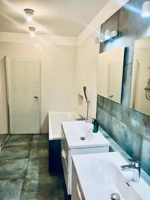 a bathroom with two sinks and a shower at DM Sunny Apartment - Krakow with free private parking in Kraków