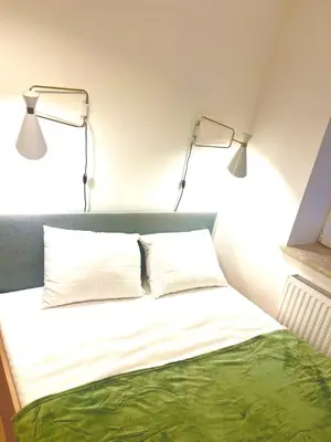 two lights above a bed in a room at DM Sunny Apartment - Krakow with free private parking in Kraków