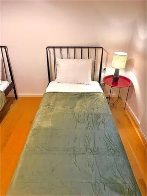 a bed in a room with a red table with a lamp at DM Sunny Apartment - Krakow with free private parking in Kraków