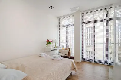 a white bedroom with a bed and a window at Old Town Apt with AC & Parking, 5 min Main Sq & Kazimierz in Kraków