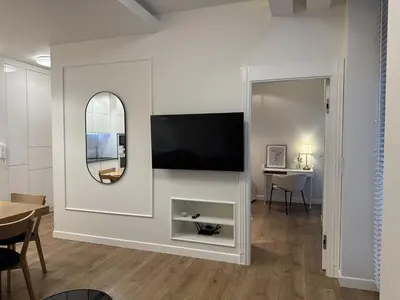 a living room with a tv and a mirror at Old Town Apt with AC & Parking, 5 min Main Sq & Kazimierz in Kraków