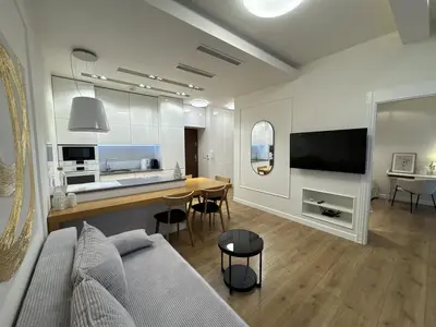 a living room with a couch and a kitchen with a table at Old Town Apt with AC & Parking, 5 min Main Sq & Kazimierz in Kraków