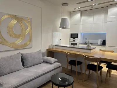 a living room with a couch and a table and a kitchen at Old Town Apt with AC & Parking, 5 min Main Sq & Kazimierz in Kraków