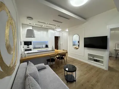 a living room with a couch and a table and a kitchen at Old Town Apt with AC & Parking, 5 min Main Sq & Kazimierz in Kraków
