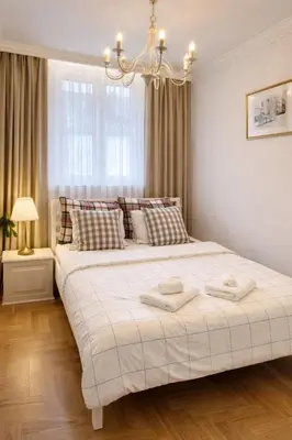 a bedroom with a large bed with two towels on it at ApAzory Kraków - przytulny apartament na wyłączność in Kraków