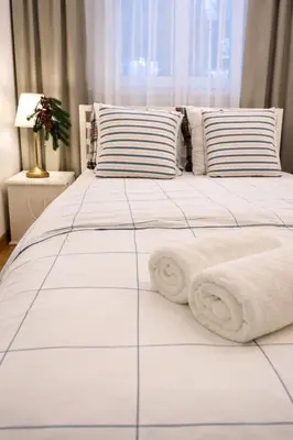 a white bed with white blankets and pillows on it at ApAzory Kraków - przytulny apartament na wyłączność in Kraków