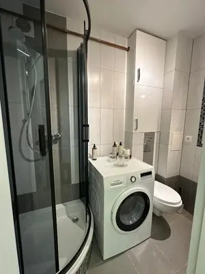 a bathroom with a washing machine and a toilet at ApAzory Kraków - przytulny apartament na wyłączność in Kraków