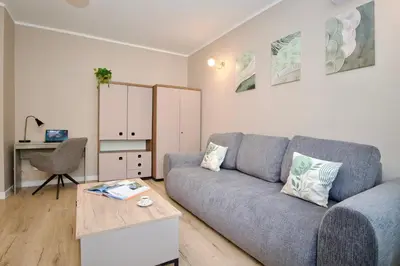 a living room with a couch and a table at Łagiewniki Apartments Free Parking in Kraków