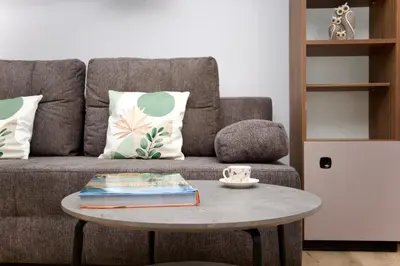 a living room with a couch and a table with books at Łagiewniki Apartments Free Parking in Kraków