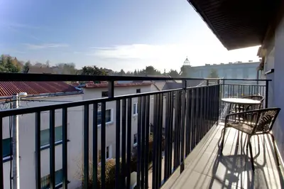 a balcony with a chair and a view of a building at Łagiewniki Apartments Free Parking in Kraków