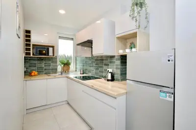 a white kitchen with a sink and a refrigerator at Łagiewniki Apartments Free Parking in Kraków