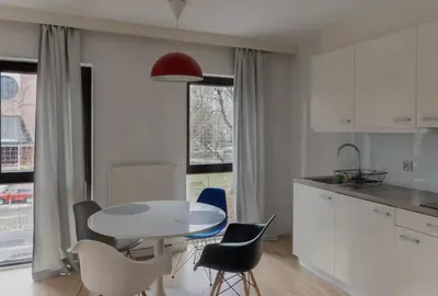 a kitchen with a white table and chairs and a table at Castor in Kraków