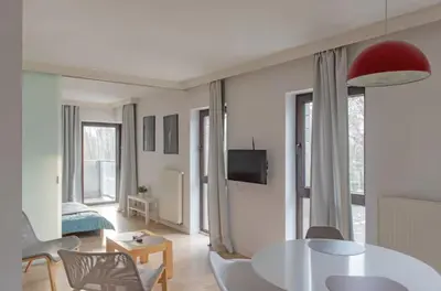 a white living room with a table and chairs at Castor in Kraków