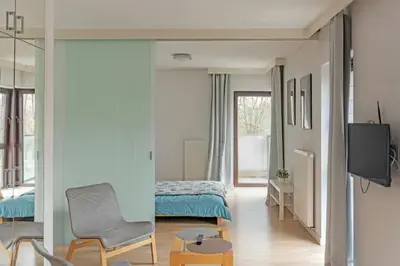 a bedroom with a bed and a tv and a chair at Castor in Kraków