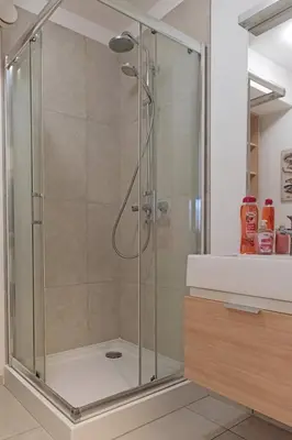 a shower with a glass door in a bathroom at Castor in Kraków
