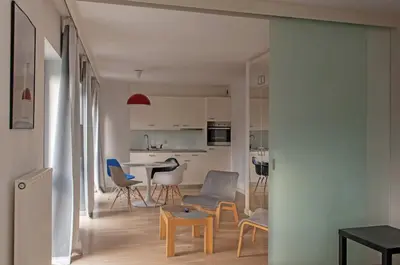 a living room and kitchen with a table and chairs at Castor in Kraków