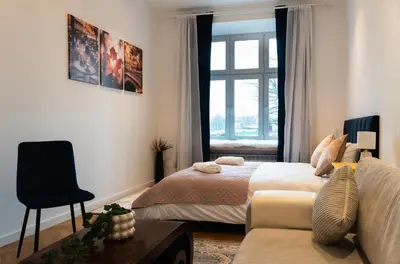 a bedroom with a bed and a couch and a window at Soniya's Castle View Apartment in Kraków